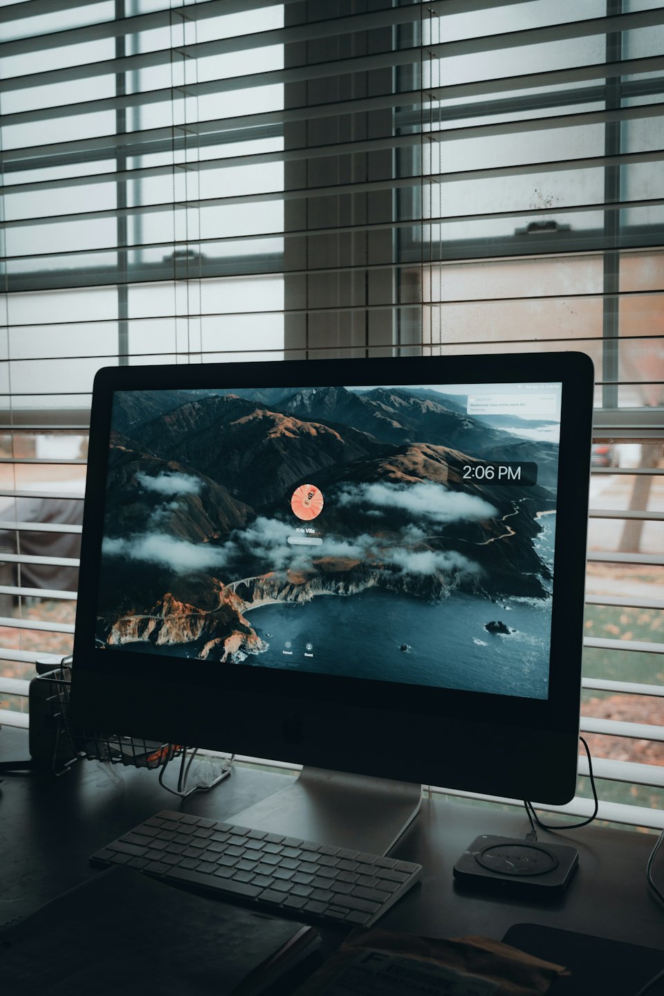 Modern computer with mountain wallpaper sits on a desk.